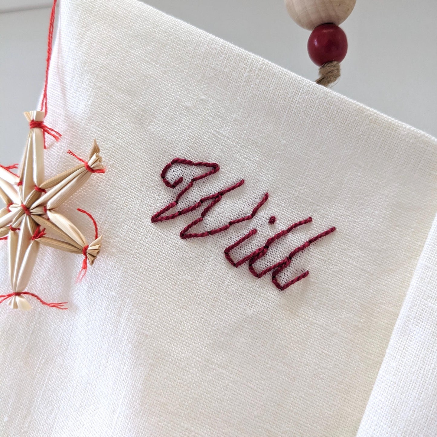 Hand embroidered ivory linen Christmas stocking with personalized name in red