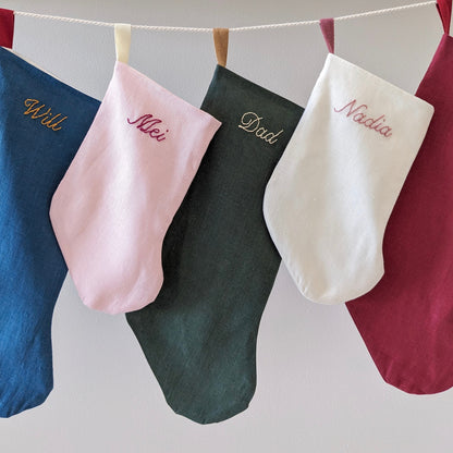 Hand embroidered linen Christmas stocking with name in blue, pink, green, ivory, and red