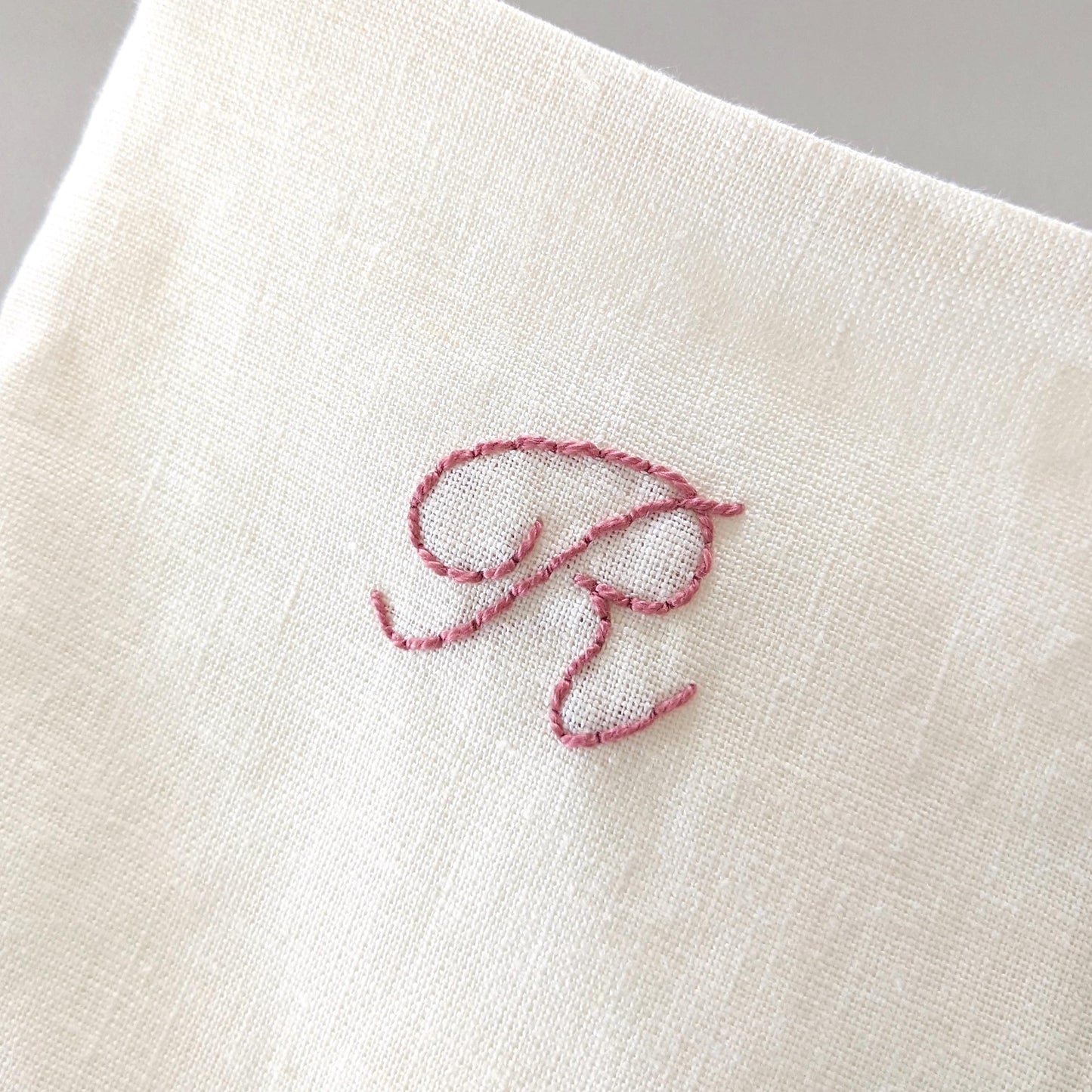 Hand embroidered linen Christmas stocking with personalized initial. Ivory with pink embroidery