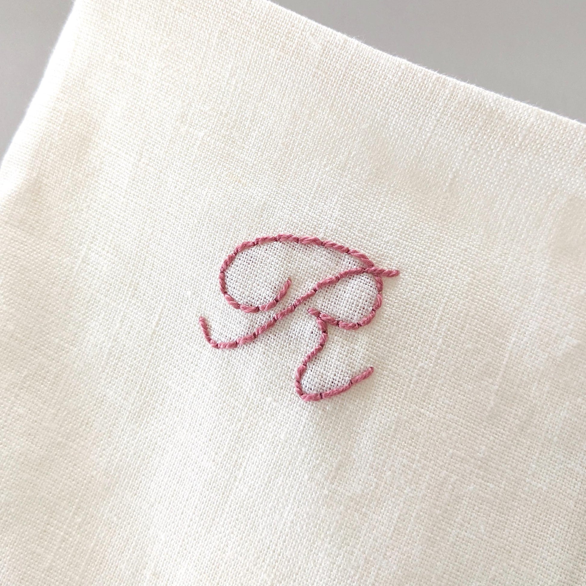 Hand embroidered linen Christmas stocking with personalized initial. Ivory with pink embroidery