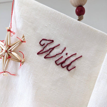 Hand embroidered ivory linen Christmas stocking with personalized name in red