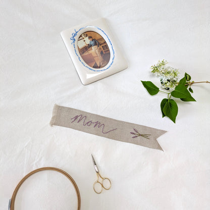 Hand embroidered linen ribbon bookmark that says Mom with a lavender motif