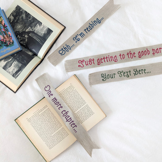 A hand painted linen ribbon bookmark that reads "Shh... I'm reading..." "Just getting to the good part..." or "One more chapter..."