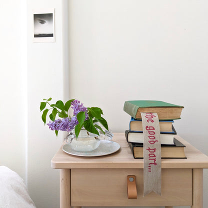 A hand painted linen ribbon bookmark that reads "Just getting to the good part..."
