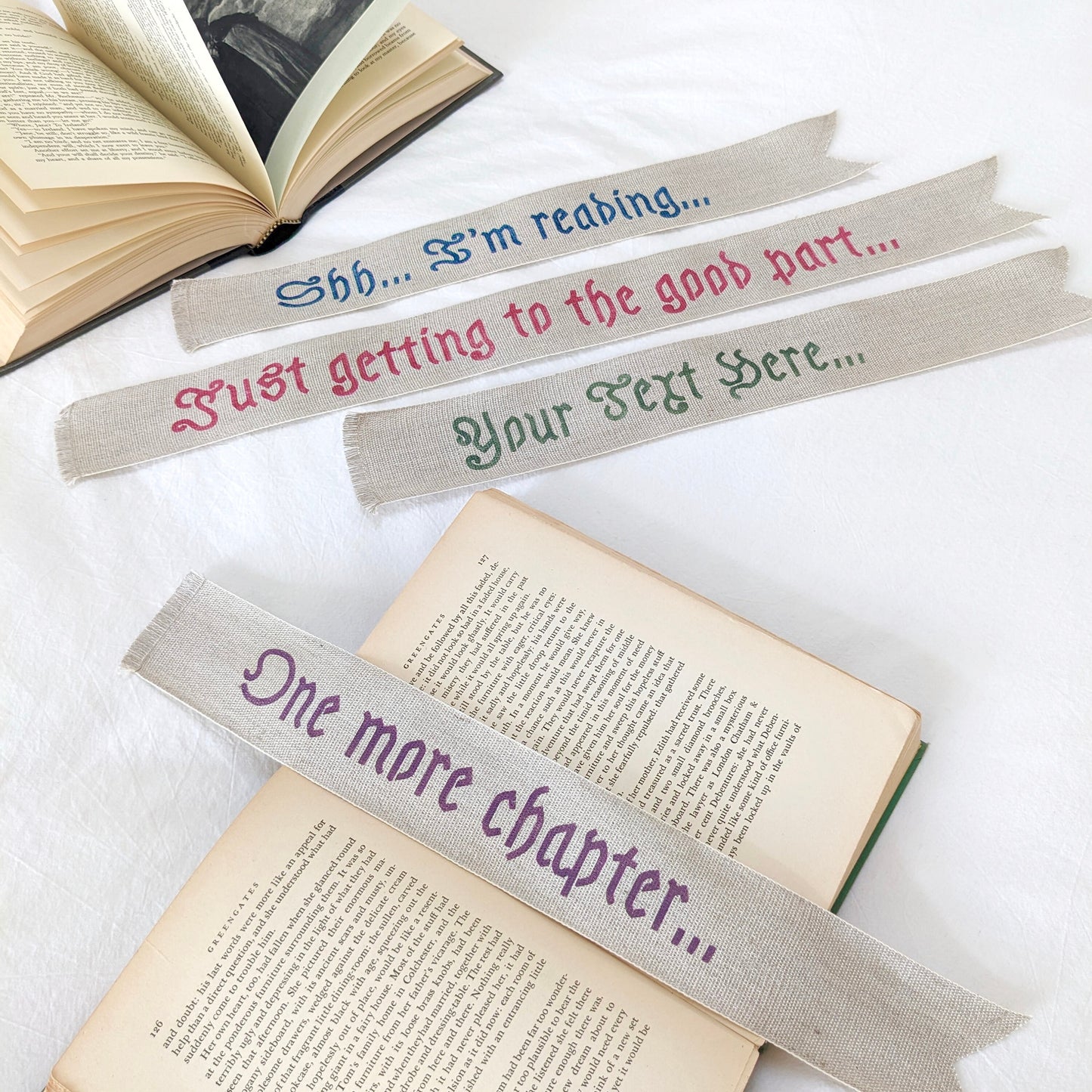 A hand painted linen ribbon bookmark that reads "Shh... I'm reading..." "Just getting to the good part..." or "One more chapter..."