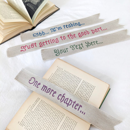A hand painted linen ribbon bookmark that reads "Shh... I'm reading..." "Just getting to the good part..." or "One more chapter..."
