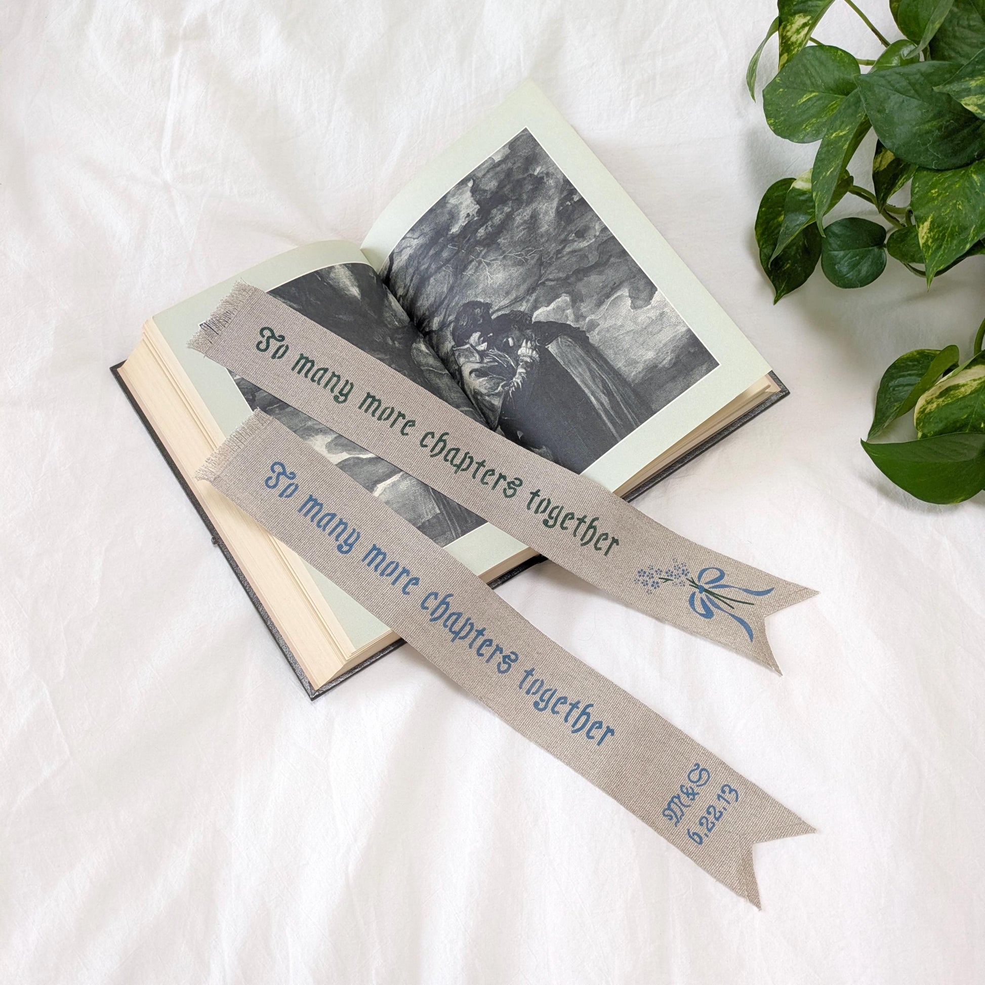 Hand painted linen ribbon bookmark that reads "To many more chapters together" with either initials and wedding anniversary date motif or forget-me-not-flower motif
